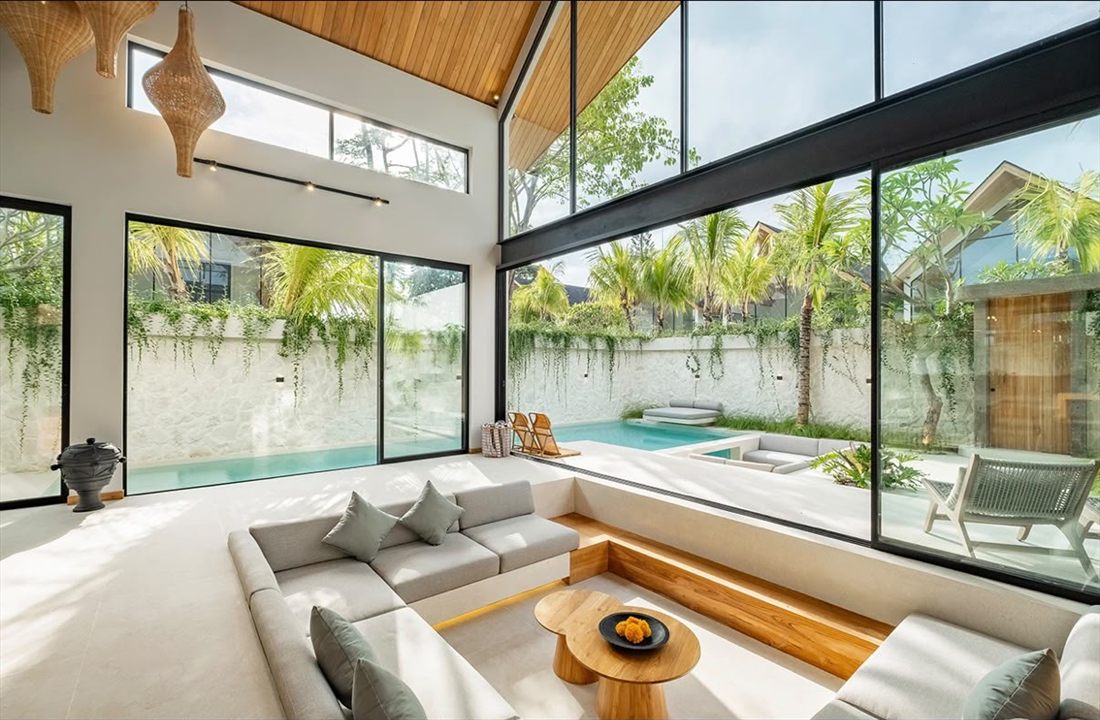 Open-plan villa living room in Bali opening onto a private pool and garden